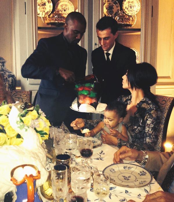 Kanye West cuts the cake for Kim Kardashian and North West